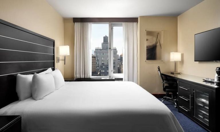 Delux king room with TV and business desk at Hilton New York Fashion District.