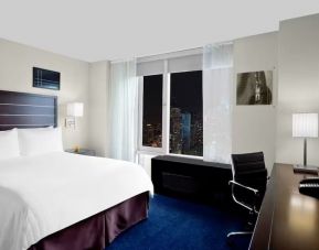 King bedroom with TV and work station at Hilton New York Fashion District.