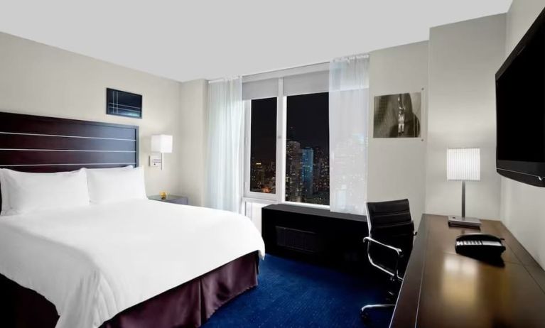 King bedroom with TV and work station at Hilton New York Fashion District.