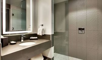 Private guest bathroom with shower at The Rose Hotel Chicago O’Hare, Tapestry Collection By Hilton.