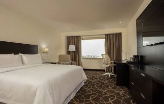 Delux king bed with TV and business desk at Doubletree By Hilton Toluca.