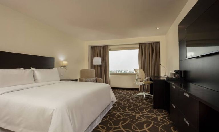 Delux king bed with TV and business desk at Doubletree By Hilton Toluca.