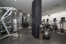 The NoMo Soho’s fitness center, with racked weights and various exercise equipment.