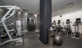 The NoMo Soho’s fitness center, with racked weights and various exercise equipment.