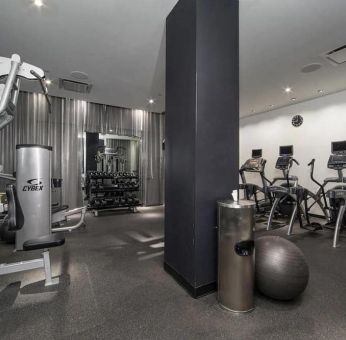 The NoMo Soho’s fitness center, with racked weights and various exercise equipment.