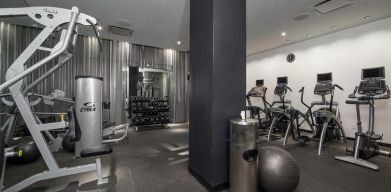 The NoMo Soho’s fitness center, with racked weights and various exercise equipment.