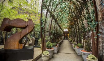 Vine covered trellis entryway leading to the lobby of the Nomo Soho in New York City.