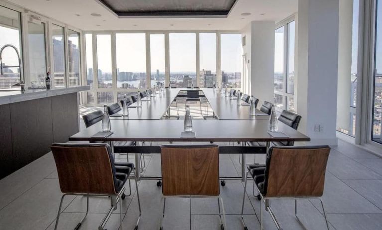 One of the hotel meeting rooms, with over a dozen seats arranged around long tables, and panoramic city views.