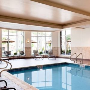 Stunning indoor pool with seating area at Hilton Garden Inn Boston Logan Airport.