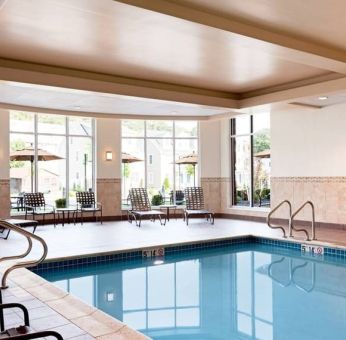 Stunning indoor pool with seating area at Hilton Garden Inn Boston Logan Airport.