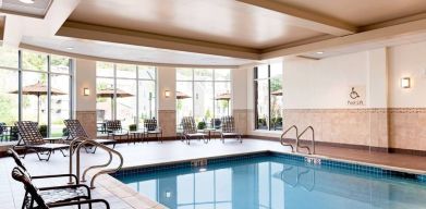 Stunning indoor pool with seating area at Hilton Garden Inn Boston Logan Airport.