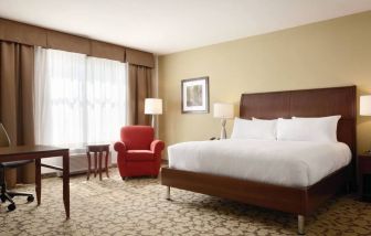 Spacious delux king bed with TV and work desk at Hilton Garden Inn Boston Logan Airport.