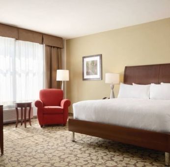 Spacious delux king bed with TV and work desk at Hilton Garden Inn Boston Logan Airport.