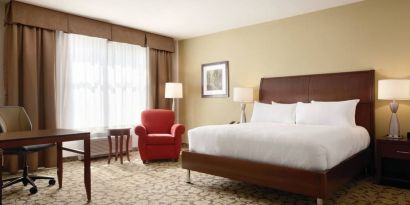 Spacious delux king bed with TV and work desk at Hilton Garden Inn Boston Logan Airport.