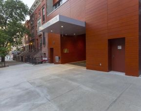 Exterior of the hotel, with large awning and nearby tree.