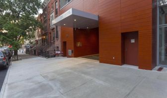 Exterior of the hotel, with large awning and nearby tree.