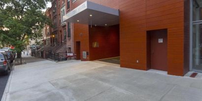 Exterior of the hotel, with large awning and nearby tree.