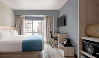 One of Wingate By Wyndham New York Midtown South/5th Ave’s guest rooms, featuring workspace desk and chair as well as a double bed.