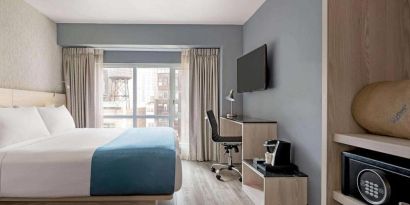 One of Wingate By Wyndham New York Midtown South/5th Ave’s guest rooms, featuring workspace desk and chair as well as a double bed.