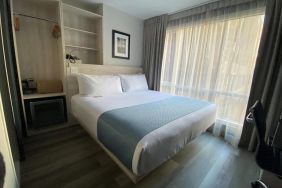 Guest room in the Wingate By Wyndham New York Midtown South/5th Ave, with double bed and nearby window.