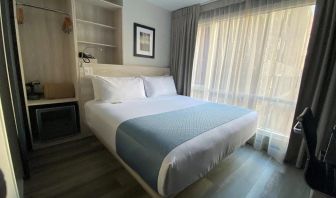 Guest room in the Wingate By Wyndham New York Midtown South/5th Ave, with double bed and nearby window.