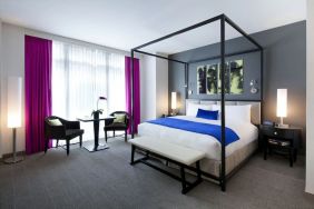 Kind bedroom with seating area at Royalton Park Avenue.