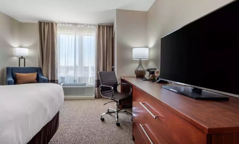 Delux king bed with TV and business desk at Comfort Inn & Suites Napanee.