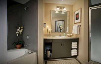 Private guest bathroom with bath and shower at Magnolia Dallas.