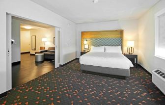 Spacious king bed with lounge area at Holiday Inn & Suites Calgary Airport North.