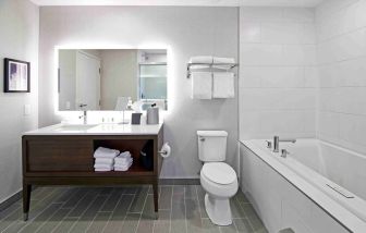 Private guest bathroom with bath and shower combo at Holiday Inn & Suites Calgary Airport North.