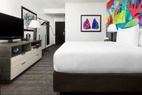 Spacious king bedroom with TV and natural light at Hotel Studio Allston.