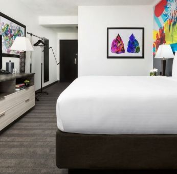 Spacious king bedroom with TV and natural light at Hotel Studio Allston.