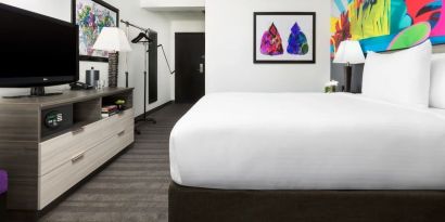 Spacious king bedroom with TV and natural light at Hotel Studio Allston.