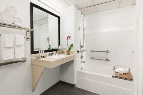 Private guest bathroom with bath and shower at Hotel Studio Allston.