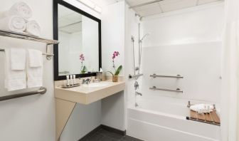 Private guest bathroom with bath and shower at Hotel Studio Allston.