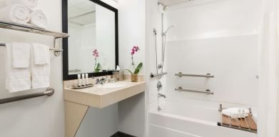 Private guest bathroom with bath and shower at Hotel Studio Allston.