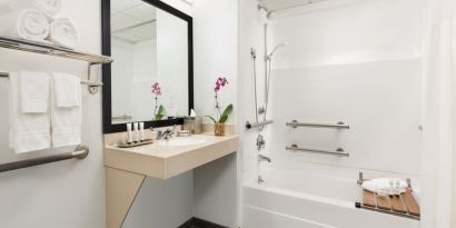 Private guest bathroom with bath and shower at Hotel Studio Allston.