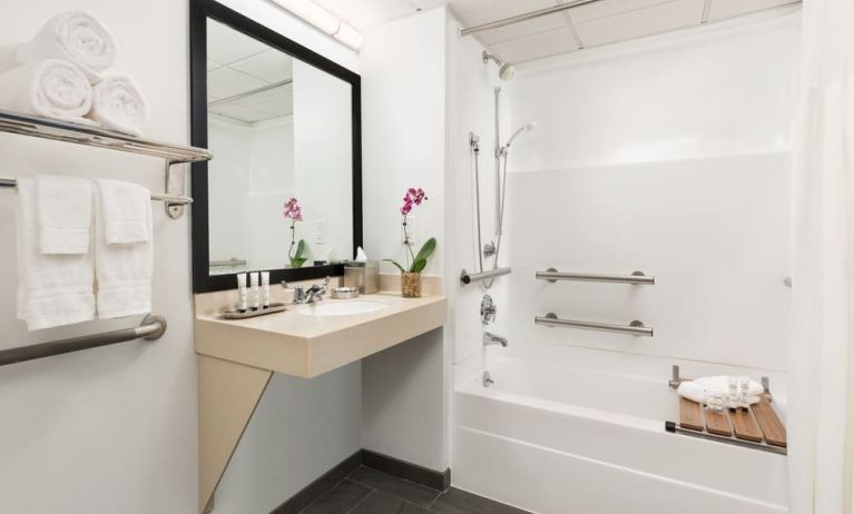 Private guest bathroom with bath and shower at Hotel Studio Allston.