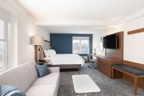 King bed with TV and business desk at Holiday Inn Express & Suites Boston-Cambridge.