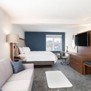 King bed with TV and business desk at Holiday Inn Express & Suites Boston-Cambridge.