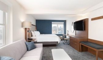 King bed with TV and business desk at Holiday Inn Express & Suites Boston-Cambridge.