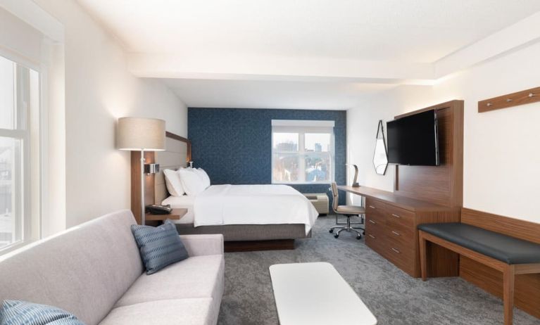 King bed with TV and business desk at Holiday Inn Express & Suites Boston-Cambridge.