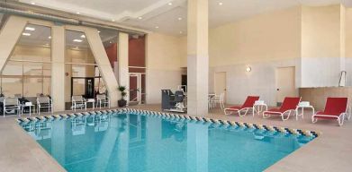 lovely indoor pool with surrounding seating area and sun beds at Homewood Suites by Hilton University City.