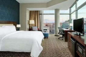 King bed with TV and natural light at Hilton Garden Inn Washington DC / Georgetown Area.