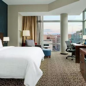 King bed with TV and natural light at Hilton Garden Inn Washington DC / Georgetown Area.