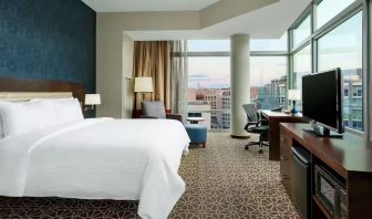 King bed with TV and natural light at Hilton Garden Inn Washington DC / Georgetown Area.