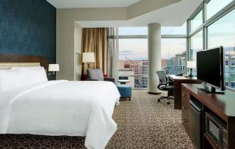 King bed with TV and natural light at Hilton Garden Inn Washington DC / Georgetown Area.