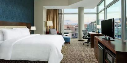 King bed with TV and natural light at Hilton Garden Inn Washington DC / Georgetown Area.