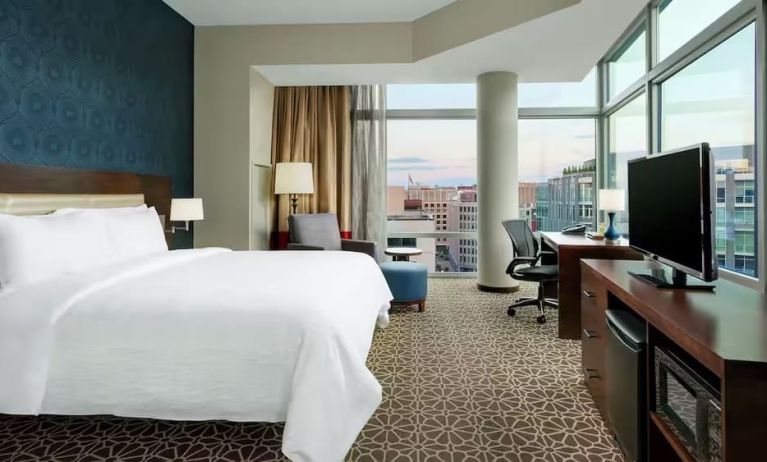 King bed with TV and natural light at Hilton Garden Inn Washington DC / Georgetown Area.