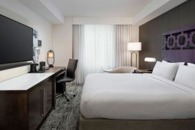 Delux king room with TV, desk, and natural light at Courtyard San Diego Downtown.